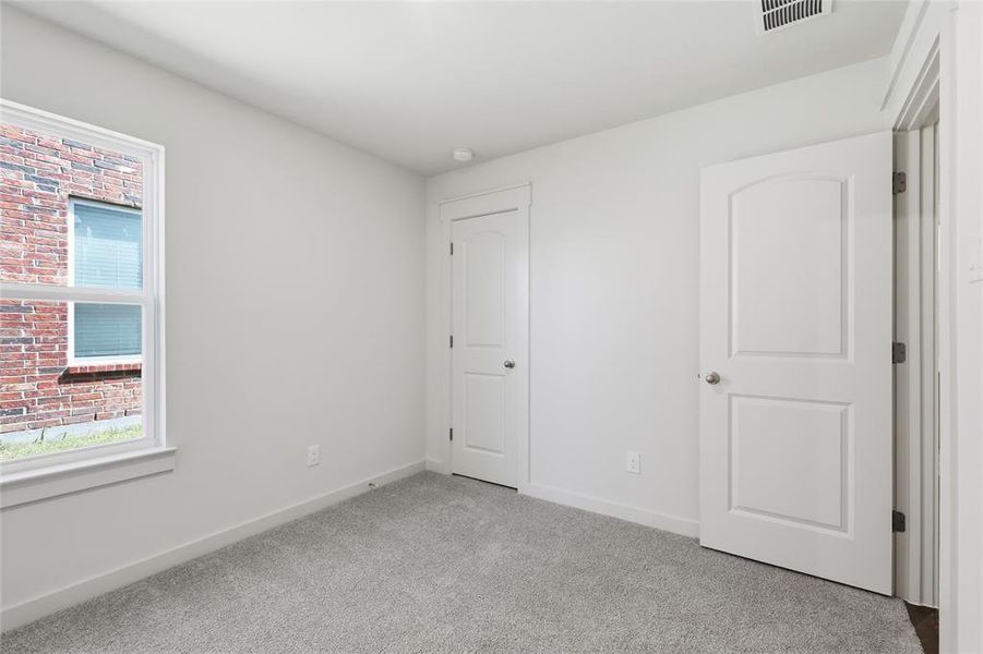 Unfurnished bedroom featuring baseboards and light carpet