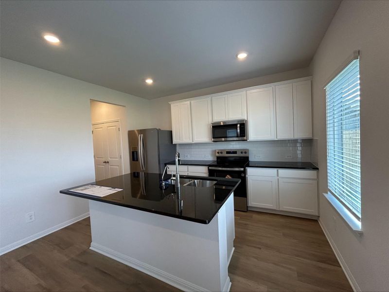Kitchen featuring appliances with stainless steel finishes, white cabinetry, tasteful backsplash, dark wood finished floors, and recessed lighting
