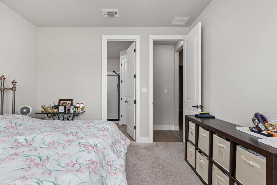 Bedroom with light colored carpet and ensuite bath