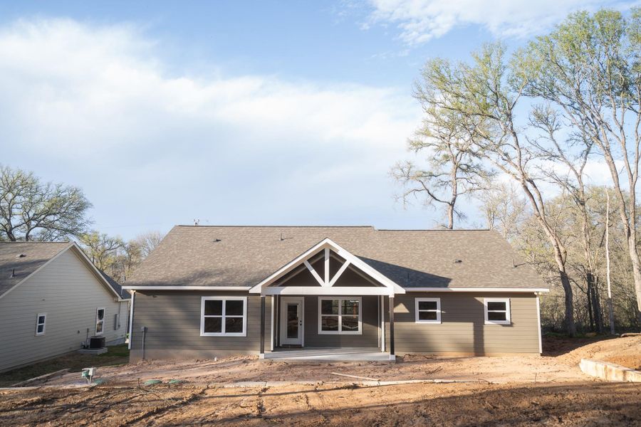 Back of house featuring central AC unit, a porch, and a shingled roof