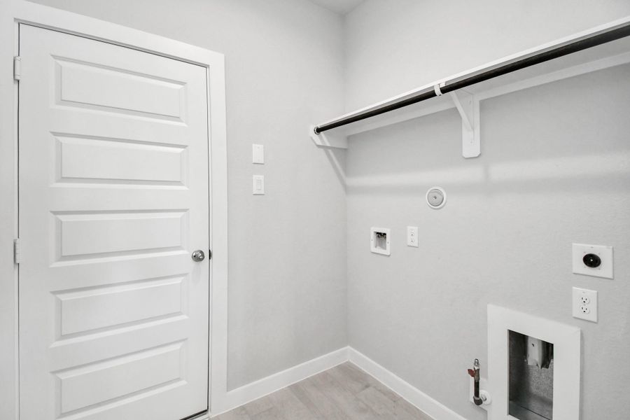 A perfect blend of functionality and comfort. Capture the essence of easy living with a first-floor laundry room, thoughtfully equipped with shelving for effortless organization. Both electric and gas connections available. Sample photo of completed home with similar floor plan. Actual colors and selections may vary. A perfect blend of functionality and comfort. Capture the essence of easy living with a first-floor laundry room, thoughtfully equipped with shelving for effortless organization. Both electric and gas connections available. Sample photo of completed home with similar floor plan. Actual colors and selections may vary.