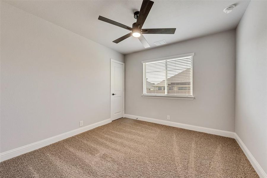 Spare room featuring light colored carpet and a ceiling fan Spare room featuring light colored carpet and a ceiling fan