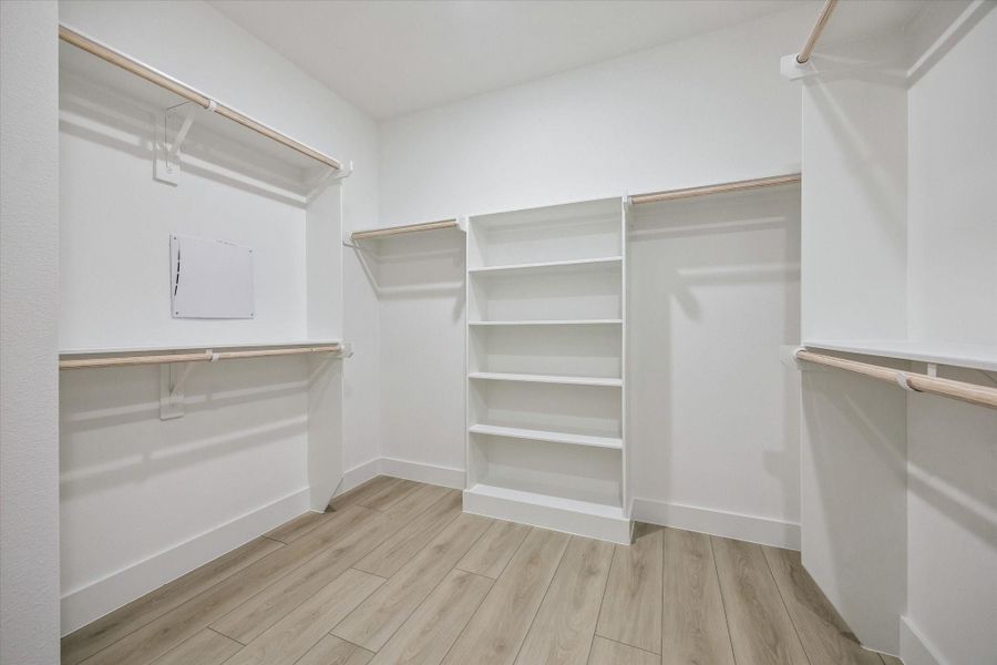 Large walk-in closet with custom-style built-in shelving Large walk-in closet with custom-style built-in shelving