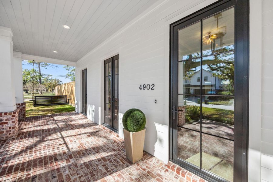 Front Patio is extra wide w/ brick & porch swing/ 2 sets of French Doors lead to the 1st Floor Study/Flexroom. A gas lantern sits above the front entry.