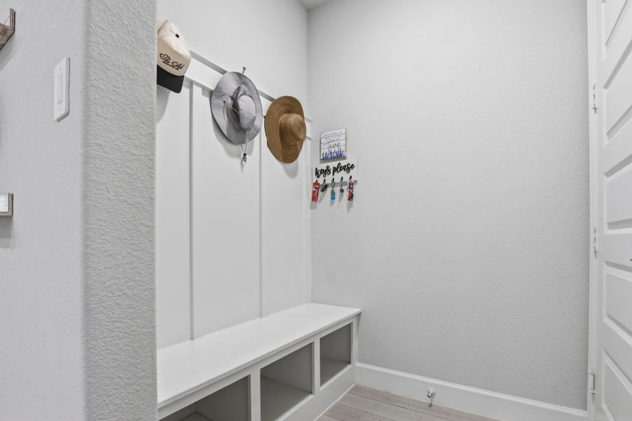 Located off the garage, this convenient stop features a drop zone bench with open cubbies and coat hooks.