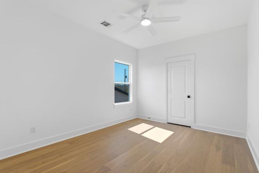 Each bedroom features hardwood flooring, a walk-in closet, a ceiling fan, and an overhead outlet ready for a mounted TV.