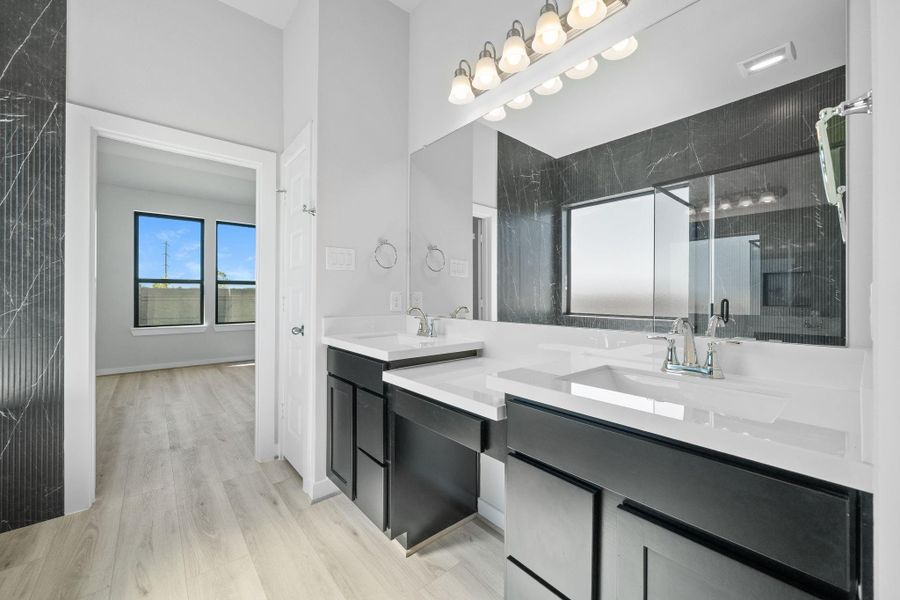 The bathroom features a striking black-and-white color scheme, with crisp white countertops and double sinks set against bold black cabinetry or accents. A large mirror stretches above the sinks, while monochrome tiles and sleek fixtures tie the modern, sophisticated design together, creating a clean and elegant space. The bathroom features a striking black-and-white color scheme, with crisp white countertops and double sinks set against bold black cabinetry or accents. A large mirror stretches above the sinks, while monochrome tiles and sleek fixtures tie the modern, sophisticated design together, creating a clean and elegant space.