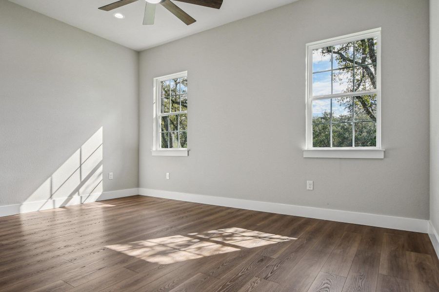 Empty room featuring dark wood-type flooring and recessed lighting