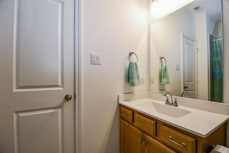 This full bathroom offers a single sink vanity with a full mirror and vanity lights above along with a convenient tub/shower enclosure.