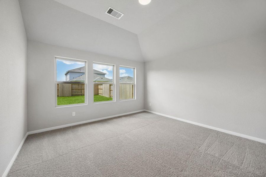 A spacious room offers ample natural light and plush carpeting, ready for personalization.