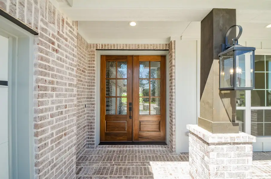 The rich wood front door, complete with elegant glass paneling, sets a warm and inviting tone as you step inside. A clean white façade and natural wood accents offer an effortlessly stylish curb appeal.