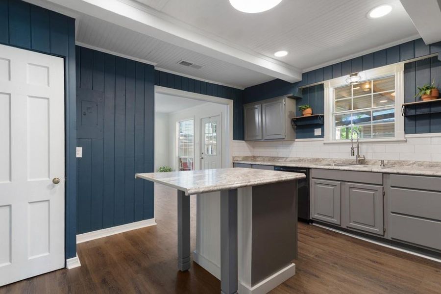 Kitchen with dishwasher, a sink, open shelves, backsplash, and beamed ceiling