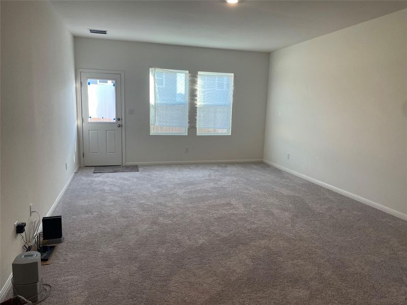 Unfurnished living room featuring carpet flooring and baseboards