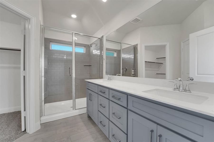 Bathroom with double vanity, a sink, visible vents, and a shower stall Bathroom with double vanity, a sink, visible vents, and a shower stall