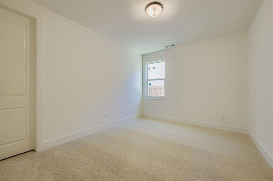 Empty room featuring light colored carpet and baseboards Empty room featuring light colored carpet and baseboards
