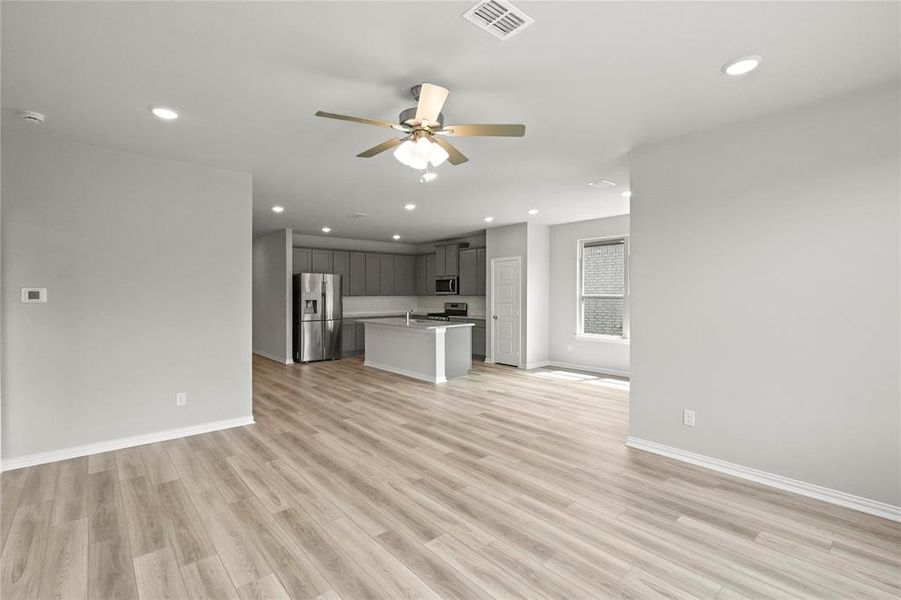 Unfurnished living room with light hardwood / wood-style flooring and ceiling fan