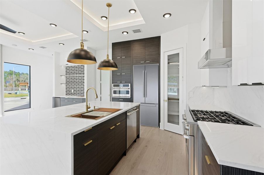 Same floorplan - different finishes. The gourmet kitchen is equipped with professional-grade stainless steel appliances, dark wood cabinetry, and a geometric tile backsplash.