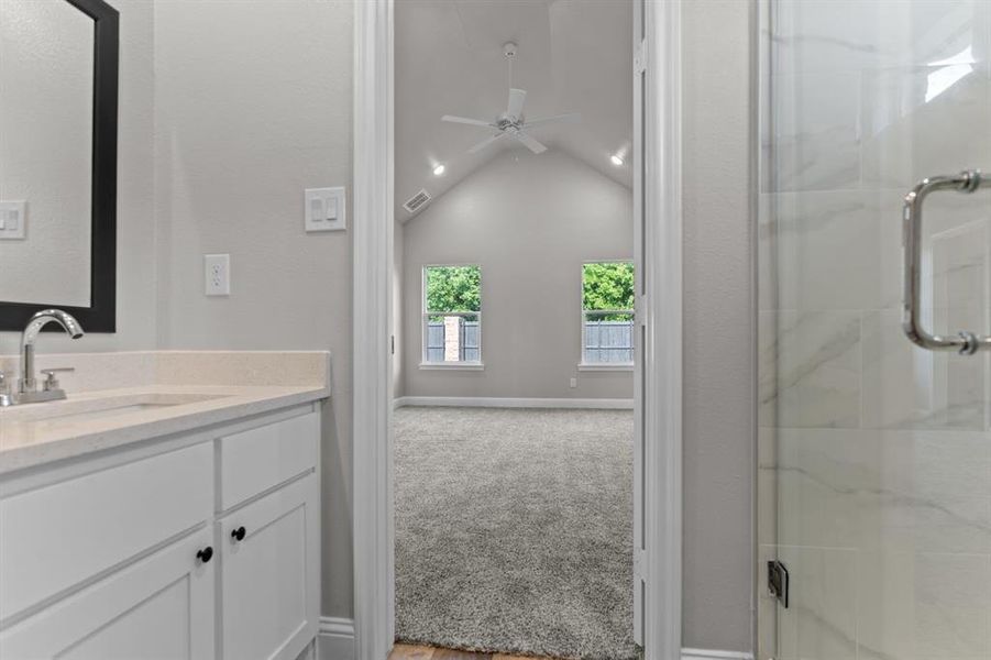 Full bath with vanity, a stall shower, vaulted ceiling, and ceiling fan Full bath with vanity, a stall shower, vaulted ceiling, and ceiling fan