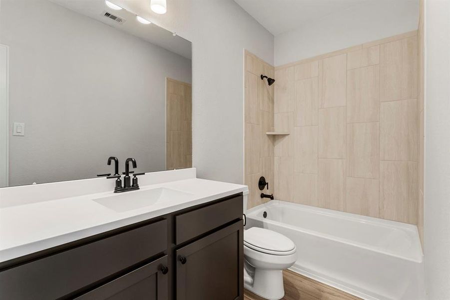 The secondary bathroom features tiled tub/shower combination.