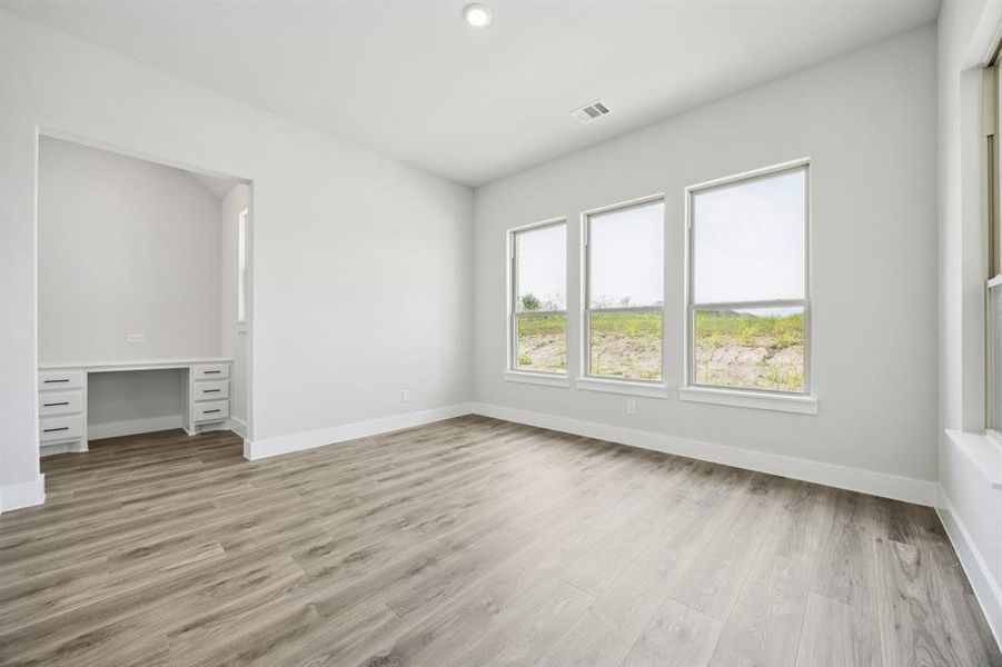 Unfurnished bedroom featuring built in study area, light wood-style floors, and recessed lighting