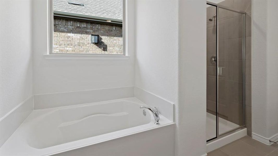 Full bath with a shower stall, a bath, and tile patterned flooring