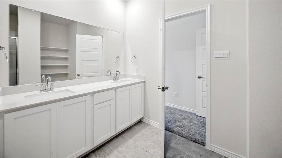 Full bathroom featuring double vanity and tile patterned flooring