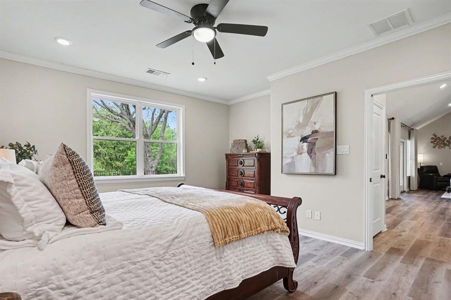 Bedroom featuring light wood finished floors, ornamental molding, ceiling fan, and recessed lighting