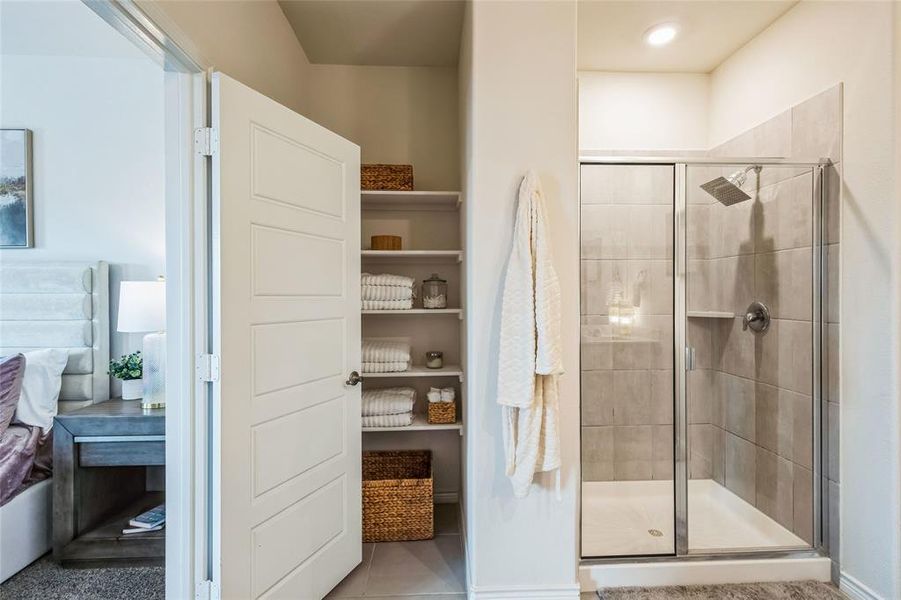 Ensuite bathroom with a stall shower, connected bathroom, and tile patterned floors
