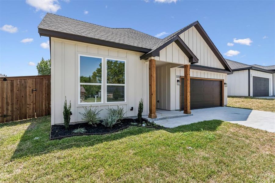 Modern farmhouse with a garage and a front lawn