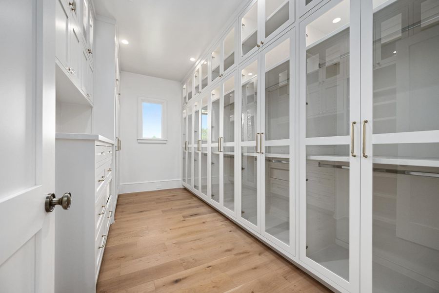 Custom cabinetry and ample storage define this organized walk-in closet with natural light.
