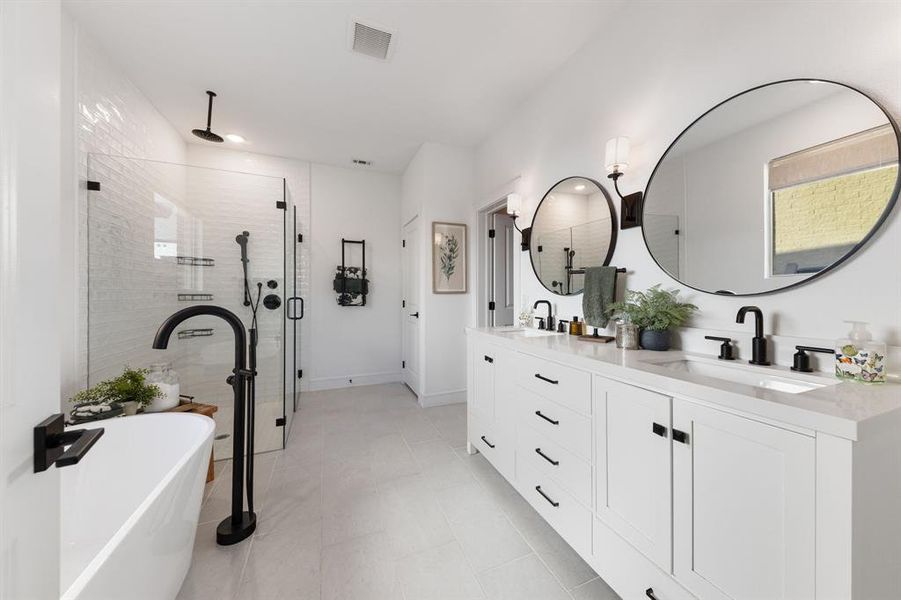 Primary bathroom with soaking tub, walk-in shower, double vanities, and generous closet space