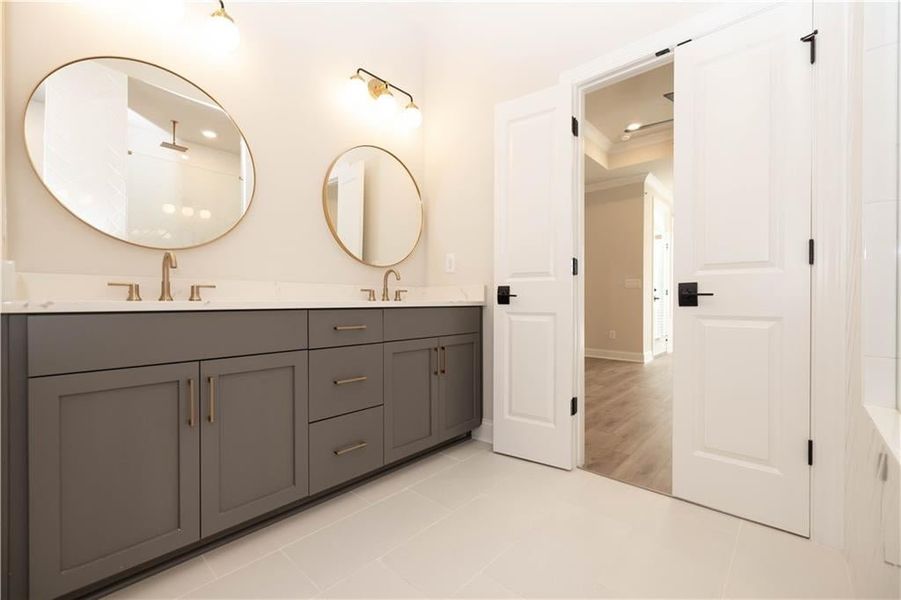 Owner's bathroom with dual vanity in Creekstone color and upgraded framed mirrors