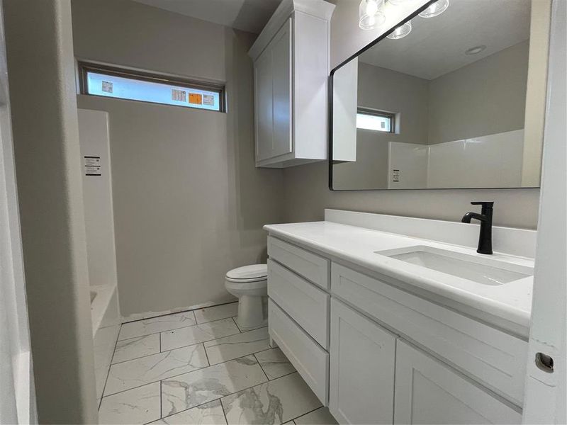 Full bathroom featuring vanity, toilet, and  shower combination