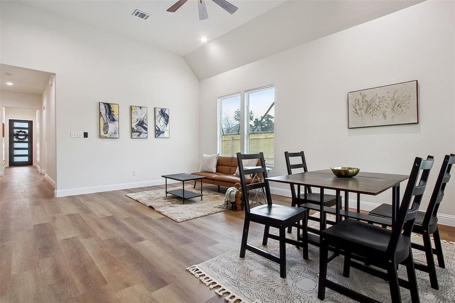 Dining area with lofted ceiling, ceiling fan, and light wood-type flooring