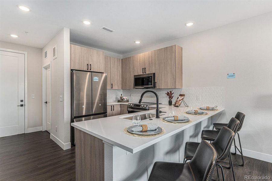 Similar unit staged; kitchen with seating