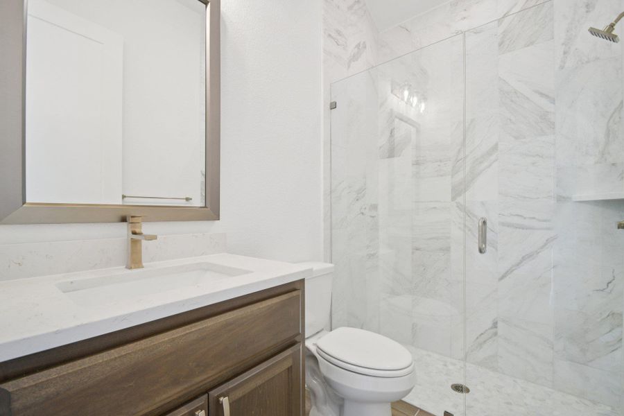 Full bathroom featuring vanity and a marble finish shower