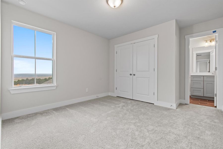 Unfurnished bedroom with light carpet, a closet, and connected bathroom