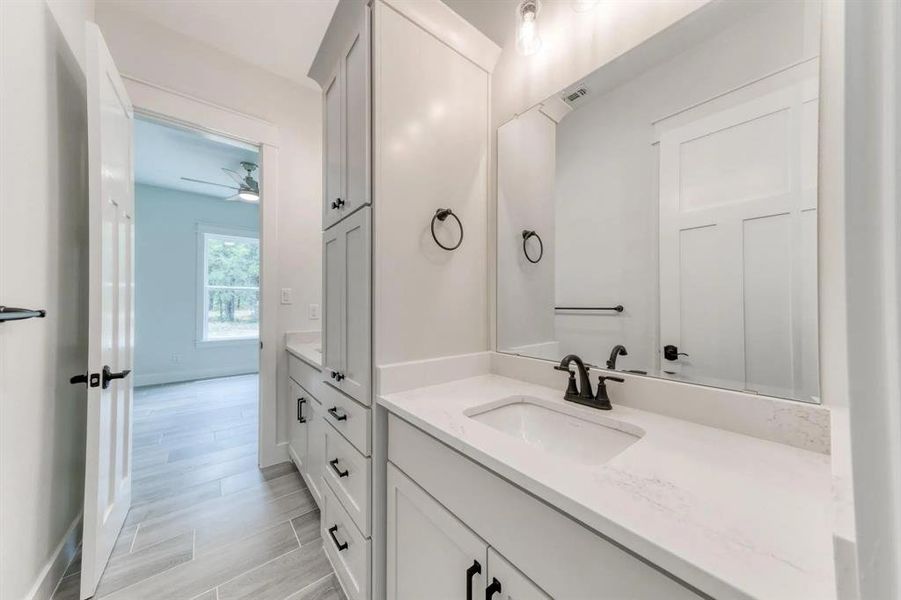 Bathroom featuring wood-type flooring, ceiling fan, and vanity