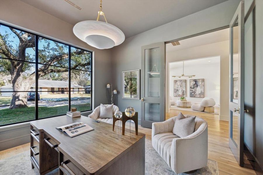 Next to the foyer, a set of double doors lead you into the study. The study features built-ins, a chandelier,beautiful paint color, and a generously sized window.