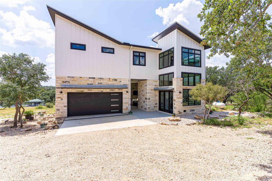 Stunning new construction waterfront home with sleek modern design and metal roof.