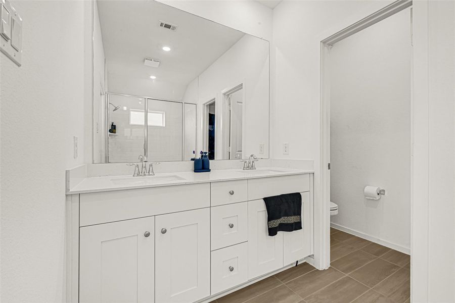 This bathroom features a modern double vanity with ample storage, a large mirror, and a glass-enclosed shower. The neutral color palette and sleek design create a clean, inviting space. This bathroom features a modern double vanity with ample storage, a large mirror, and a glass-enclosed shower. The neutral color palette and sleek design create a clean, inviting space.