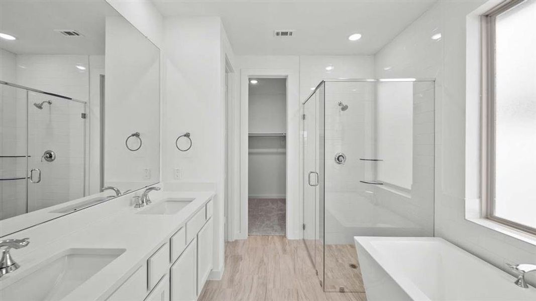 Primary Bathroom with double sinks and nearly frameless shower