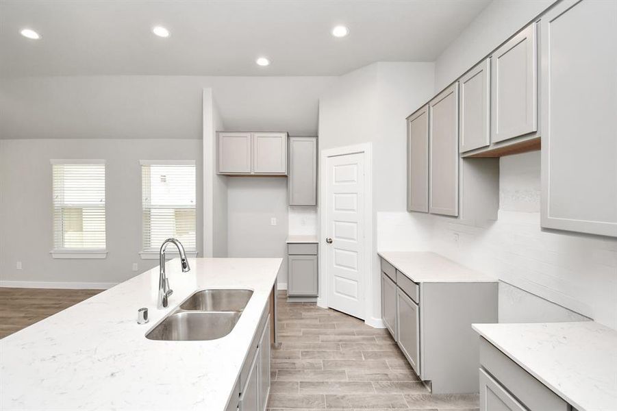 Discover another perspective of this stunning kitchen, generously appointed with an abundance of counter space. Sample photo of similar plan. Actual colors and selections may vary.