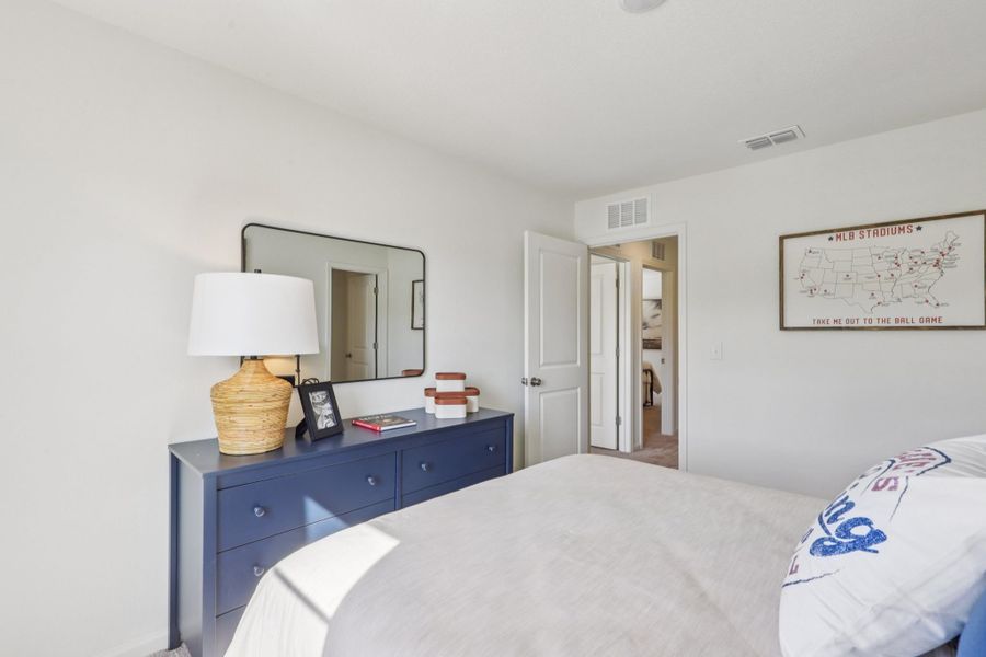 A bedroom with a bed and a mirror. A bedroom with a bed and a mirror.