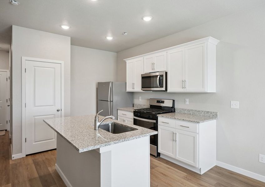 The kitchen has stainless steel appliances and plank flooring. The kitchen has stainless steel appliances and plank flooring.