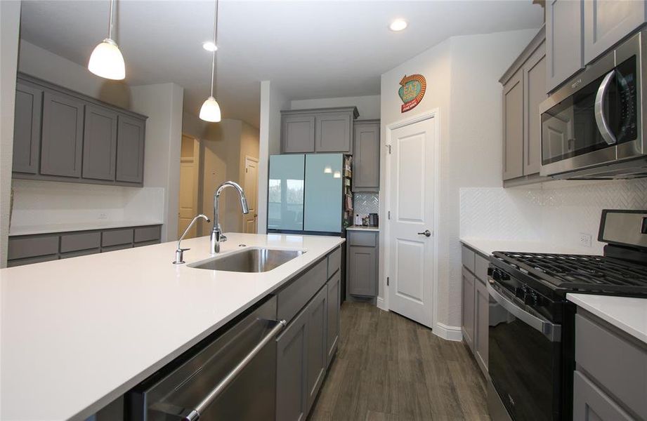 Kitchen with decorative lighting, gas stove, built-in microwave, upgraded KitchenAid Stove and plenty of cabinets