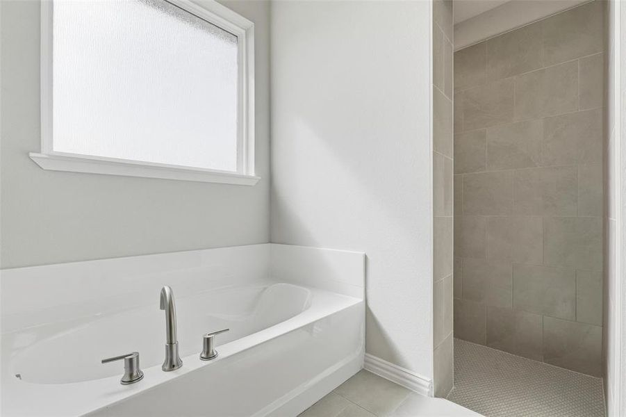 Full bathroom with a garden tub, tile patterned floors, and a tile shower Full bathroom with a garden tub, tile patterned floors, and a tile shower