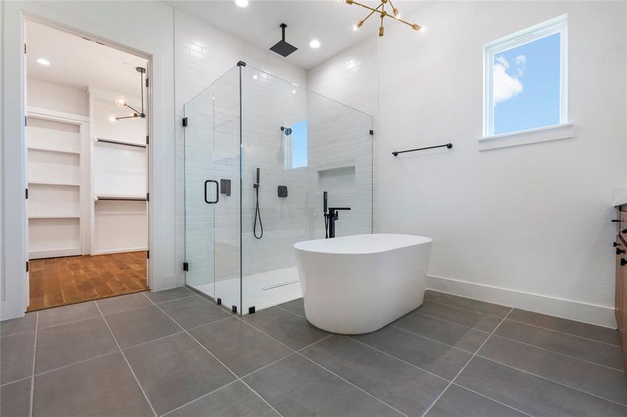 Bathroom featuring vanity, an inviting chandelier, plus walk in shower, and tile patterned floors