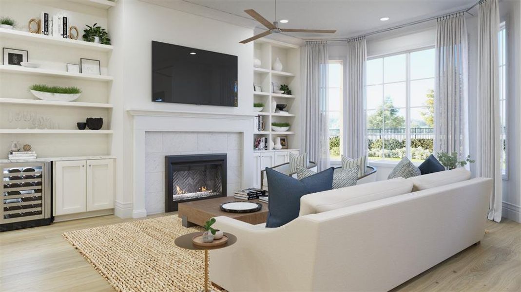 Living room with a fireplace, beverage cooler, ceiling fan, light hardwood / wood-style flooring, and built in shelves, beverage side shelves and cabinets included.  May add right side cabinetry if still possible when purchased.