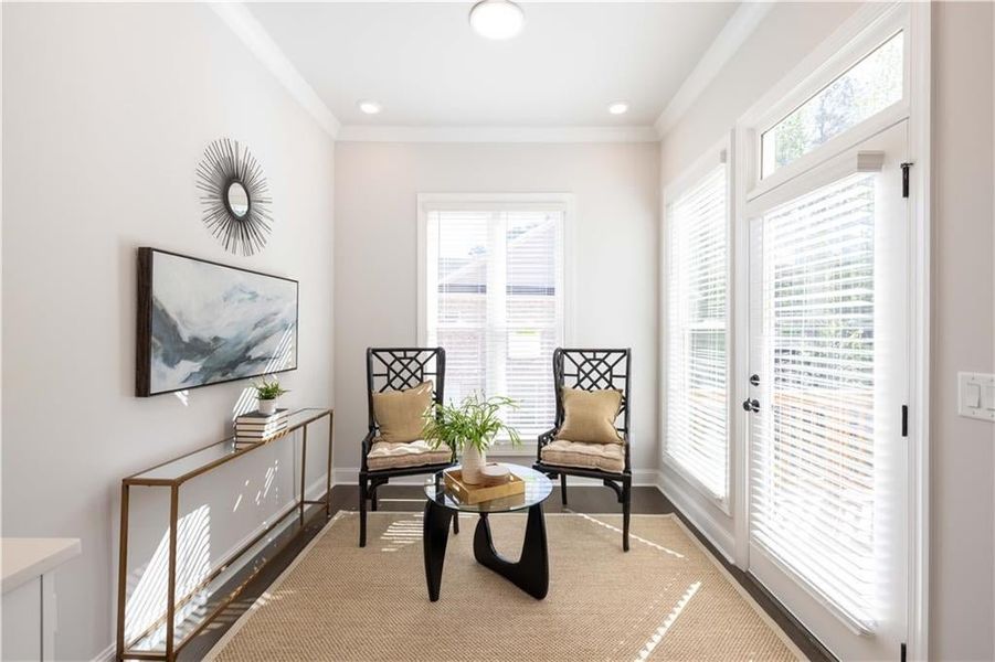 Living area with recessed lighting, baseboards, crown molding, and wood finished floors